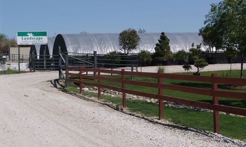The gravel drive and white fence at the Landscape Source entrance